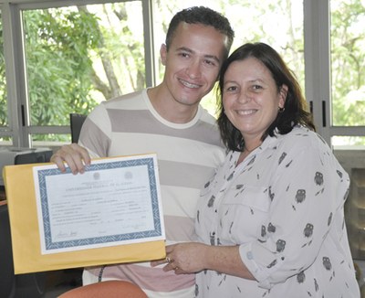 Cristiano exibe orgulhosamente o diploma durante a colação de grau presidida pela vice-reitora Rachel Rocha | nothing