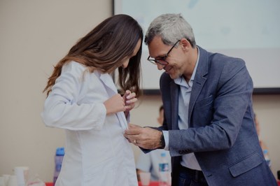 Familiar veste jaleco na nova acadêmica de Medicina