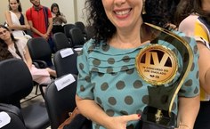 Diretora da FDA, Elaine Pimentel, exibe, orgulhosa, o troféu de seus alunos