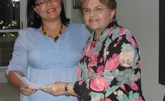 Sabrina recebe as boas vindas da Reitora com o broche da Ufal