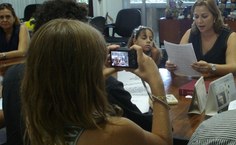 Enquanto Daniela lê o termo de posse, uma de suas filhas grava e a outra acompanha a leitura atentamente