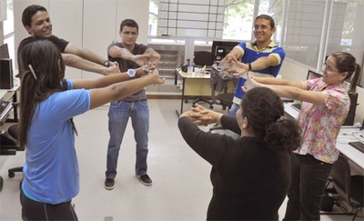 Equipe da Ascom durante pausa para fazer alongamentos com a instrutora Anna Cecília