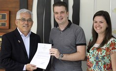 Acompanhado pela esposa, Ênio Bassi recebe termo de posse das mãos do reitor Eurico Lôbo