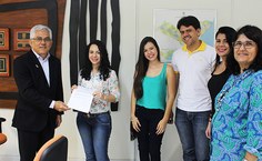 Acompanhada da família e amigos, Aline recebe termo de posse das mãos do reitor Eurico Lôbo