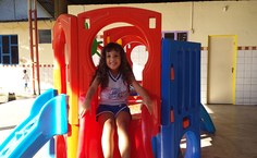 A pequena Mel se diverte no parquinho do NDI enquanto aguarda para participar das filmagens