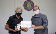 O aposentado José David Pacheco recebe a homenagem do pró-reitor Estudantil, Alexandre Lima