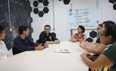 A servidora Camila em reunião com a equipe da Proginst