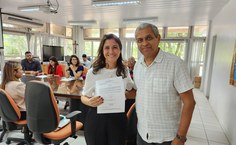 Nathalia Feidelis, nova docente da Faculdade e Nutrição, recebe termo de posse do professor José Bento, chefe de gabinete