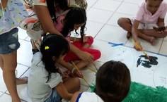 Amanda Aquino auxiliando as crianças na atividade