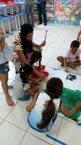 Amanda Aquino auxiliando as crianças na atividade
