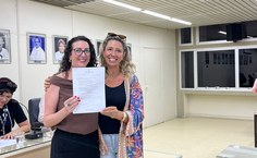 Docente Lidiane Friderichs sendo prestigiada pela professora do curso de História, Flávia de Carvalho