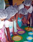 Crianças aprendendo a fazer pizza