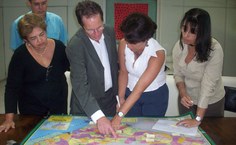 Secretário, reitora e professoras observam os pólos no mapa de Alagoas