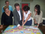 Secretário, reitora e professoras observam os pólos no mapa de Alagoas