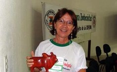 professora Edma Carvalho de Miranda, exibindo o prêmio