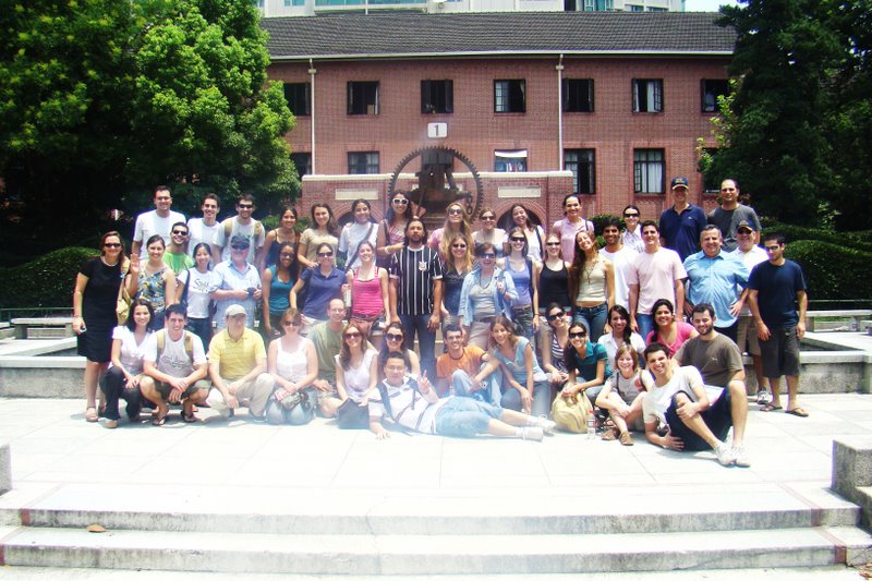 todos os brasileiros que participaram do curso em frente ao simbolo da Universidade de Shanghai