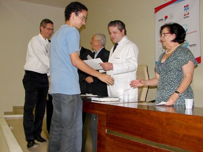 Heleno Pontes e Eduardo Setton recebendo certificado de excelência acadêmica por trabalho apresentado