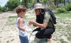 Voluntária equipa criança para a caminhada ecológica