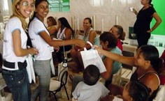 Alunas entregam kits a participantes