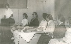 Professora Bárbara Allen, em pé, atuante na abertura do HU e do curso de Enfermagem da universidade