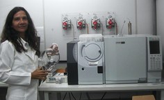 Simone ao lado do cromatógrafo com dector de massas para a identificação de substâncias