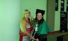 Maria Lúcia Farias representa os pais e recebe flores da filha, agora assistente social