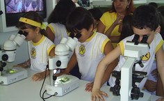 Microscópios manuseados por alunos visitantes