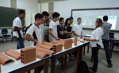 Os visitantes acompanham atentos as explicações de alunos e professores