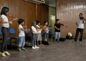 Crianças tocam violino na abertura da Semana de Educação Musical