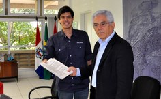 Ciro Quintella, representante da Arco, entrega contrato ao professor Eurico