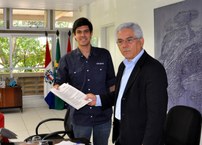 Ciro Quintella, representante da Arco, entrega contrato ao professor Eurico