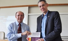 O diretor Luis Antônio entrega informativo sobre enconomia