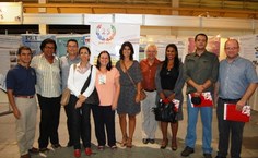 Tutores posam ao lado da vice-reitora, Rachel Rocha, em frente à mostra dos trabalhos