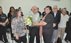 Maestro Benedito Fonseca recebe flores de corista em reconhecimento ao seu trabalho pioneiro