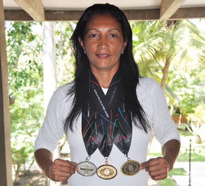 Atleta Simone Lima com as três medalhas (prata, ouro e bronze) conquistadas na Irlanda do Norte. | nothing