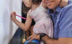 A pequena Marília desenha com o pai