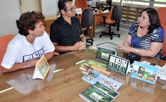 A vice-reitora Rachel Rocha recebe o calendário da equipe do MHN