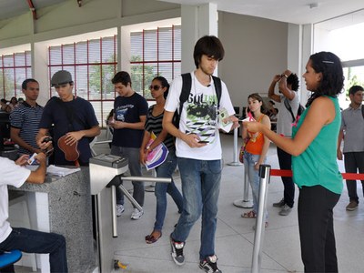 Equipe distribui convites e laços rosa no RU