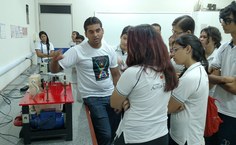 Estudantes do ensino médio acompanham a apresentação de experimentos