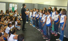O monitor Daniel Lima regendo o coro infantil da Escola Municipal João Sampaio