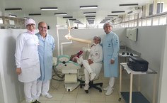 Professora Patrícia Nascimento, à direita, de jaleco azul, acompanhando o atendimento