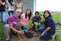 Professor Vitor Lima ao lado dos alunos durante o plantio da primeira muda de árvore.