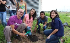 Professor Vitor Lima ao lado dos alunos durante o plantio da primeira muda de árvore.