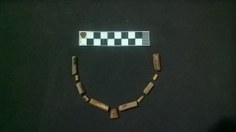 Colar de contas de ossos ossos de animais encontrado junto aos esqueletos