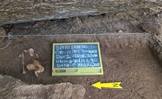 Ossos humanos sendo evidenciados durante a escavação