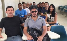 Claudevan, deficiente visual, em sala de aula com o professor Marco Antônio Chalitta e colegas de curso