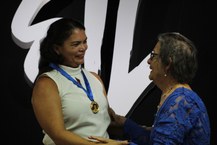 Sil da Capela recebe medalha entregue pela senhora Edna Leite, mãe do saudoso Gustavo Leite. Foto: Anna Sales