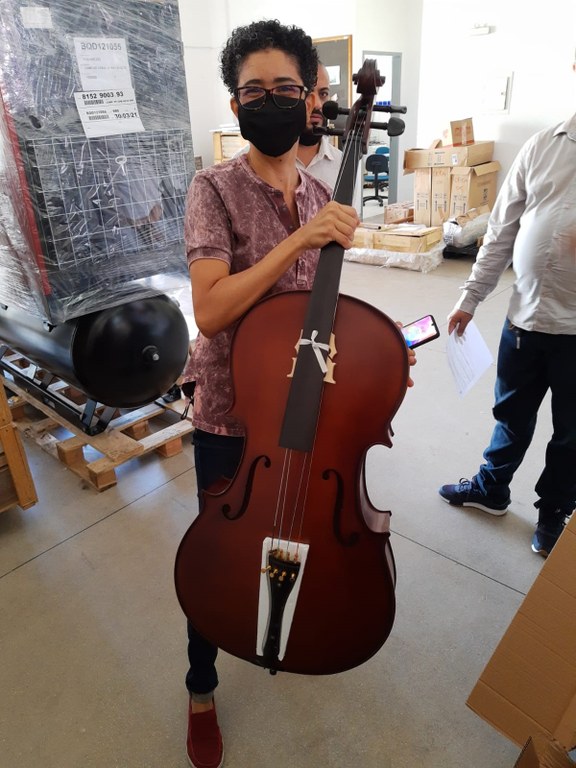 Professora Miran Abs exibindo um dos violoncelos comprados