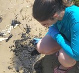 pesquisadorada Ufal recolhendo amostras do óleo derramado no litoral