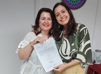 Professora Angela Canuto, diretora da Famed, entrega termo de posse à nova docente Tainá Carvalho